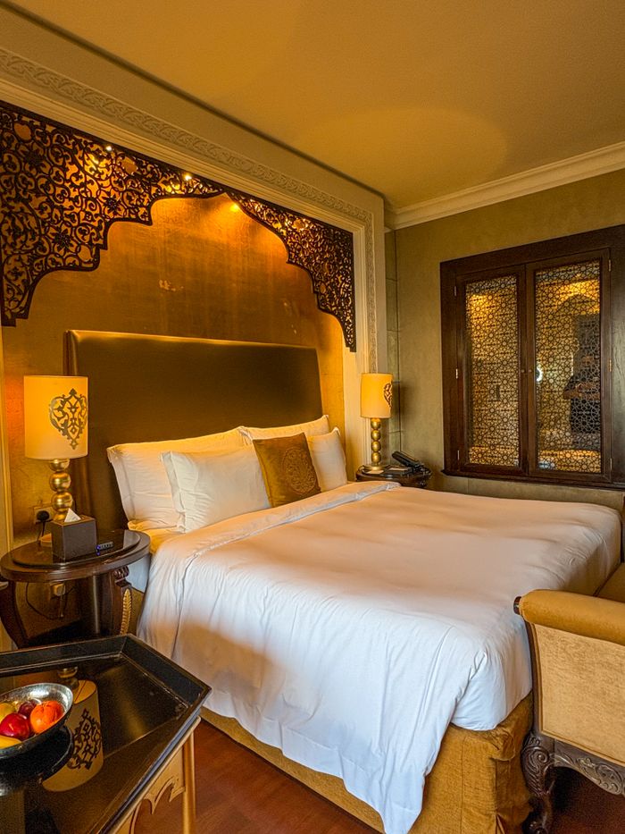 Crafting Captivating Headlines: Your awesome post title goes here Elegant hotel room in Dubai with ornate decor and plush bedding.