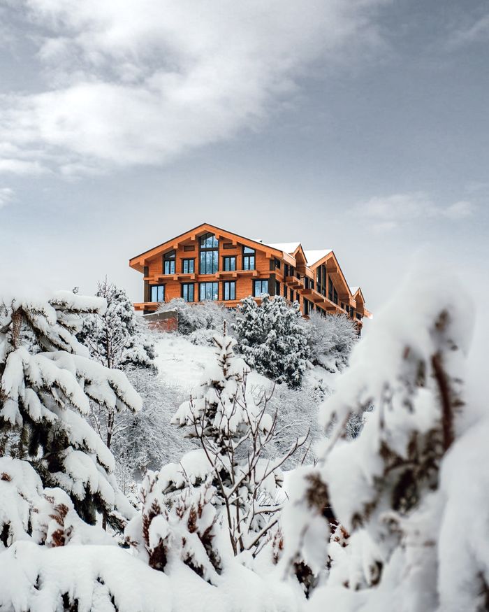 story-02 A picturesque mountain resort surrounded by snow-covered trees under a cloudy sky in Uzbekistan.